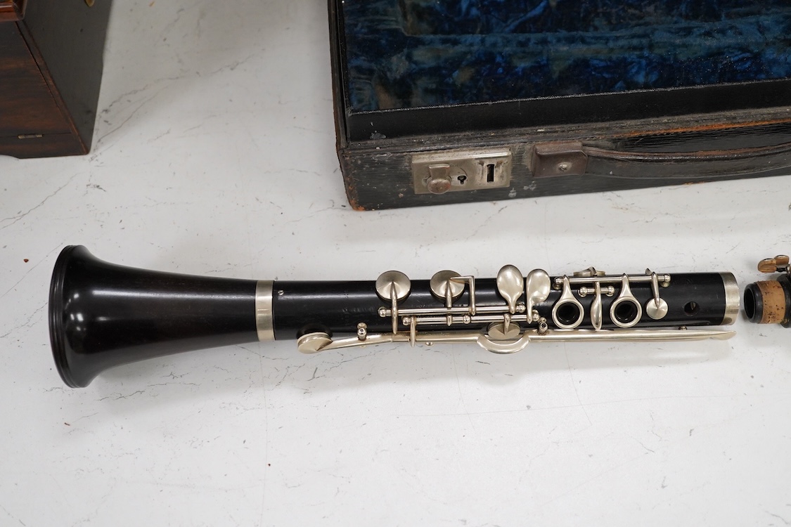 An early 20th century wooden Boosey and Hawkes clarinet in a fitted leather case